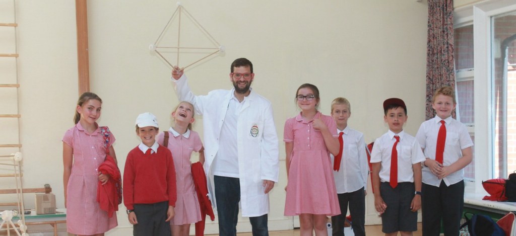Professor Brainwave holding a tetrahedron with pupils